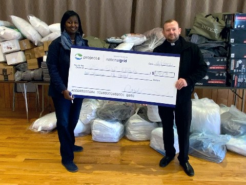 Gwen Sanders, National Grid community coordinator, presents Rev. Mykola Andrushkiv with a check for $1,500.