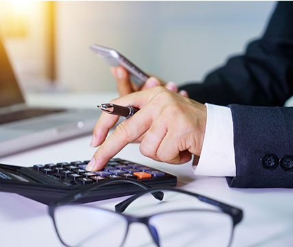 Hands typing on calculator