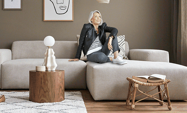 Woman sitting on couch and background changing between home and outdoors