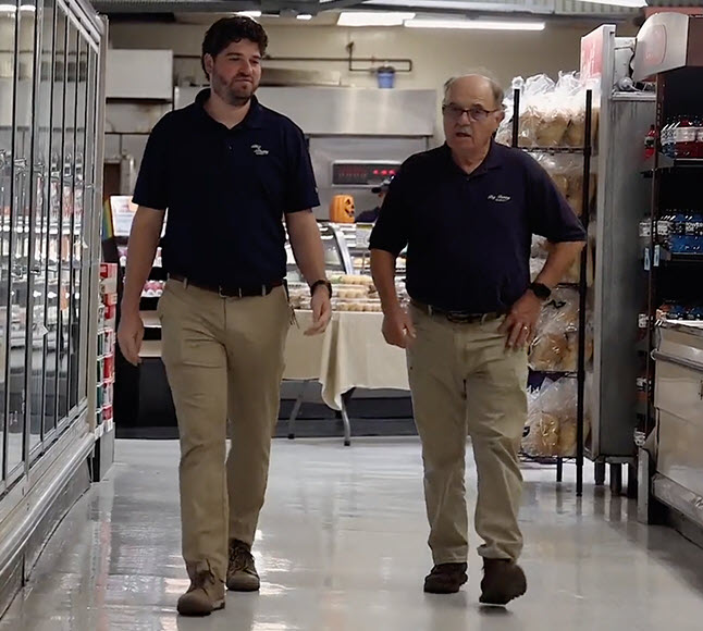 Two workers walking down the store aisle