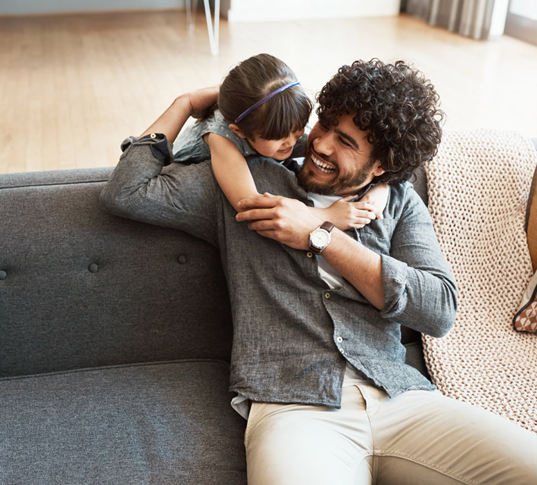 child hugging dad and they are laughing