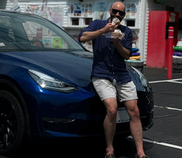 Man eating ice cream in front of an EV