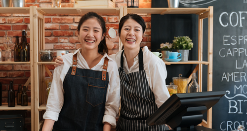 Two small business owners smiling big