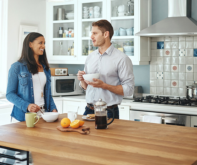 man and woman eating in kitchen